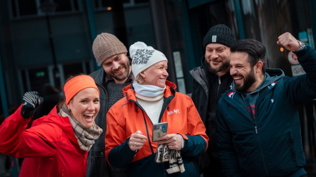 5 mennesker står sammen, ute og jubler smilende.