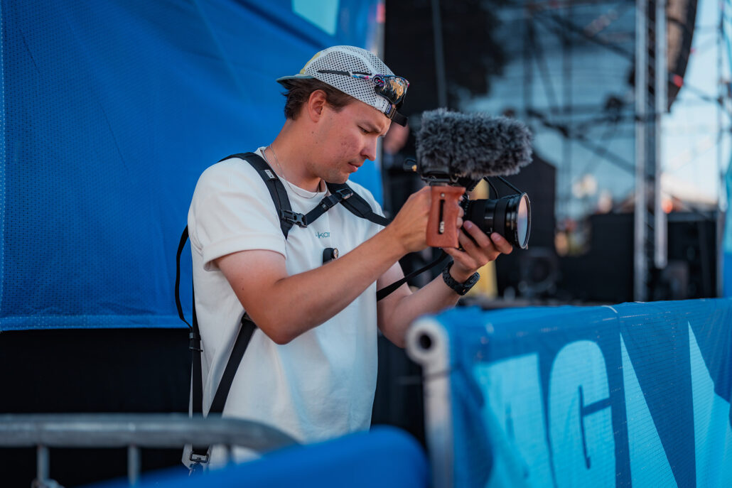 Sondre fra Akari fotograferer blandt messestands på Kongsberg Agenda