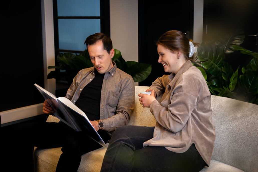 Geir i Akari sitter sammen med kollega Pia og blar i en bok